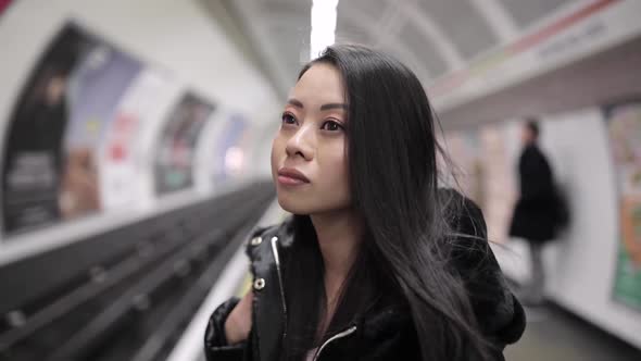 Slow motion shot of smiling Chinese woman at underground station