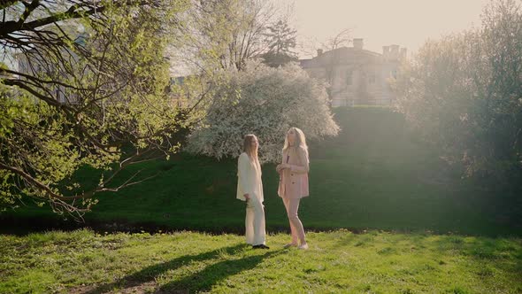 Two females persons talking in park outside. Young adult women spending time together outdoors