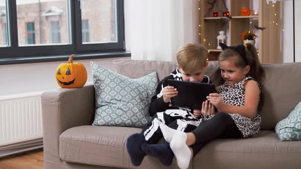 Kids in Halloween Costumes with Tablet Pc at Home