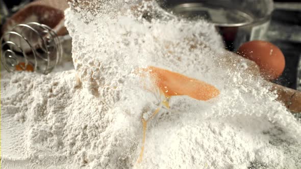 Super Slow Motion Raw Egg Falls Into a Pile of Flour