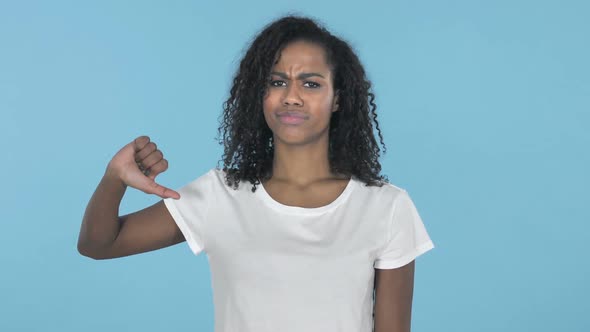 African Girl Gesturing Thumbs Down Isolated on Blue Background