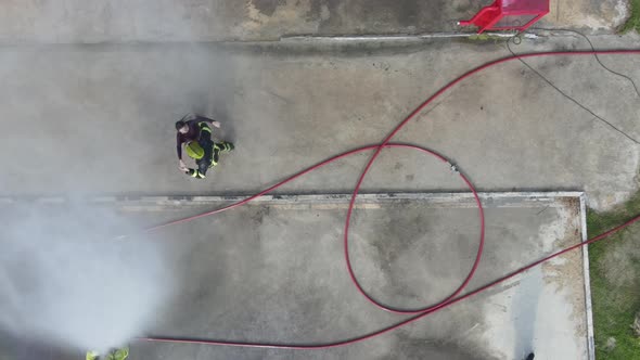 Top or aerial view of fireman with girlfriend enjoy with water spraying by man hold girlfriend