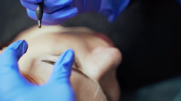 Procedure of Eyebrow Tattoo with Using a Needle for Applying a Dye in a Beauty Salon