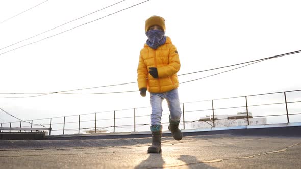 Charming Caucasian Boy Dancing on the Street in the Background of the Sunset