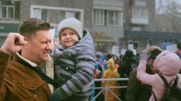 Single Father with Child on Political Rally Carrying Kid with Arm Waving Fist