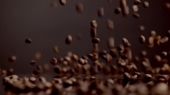 Brown Coffee Grains Falling on Surface Bouncing Closeup