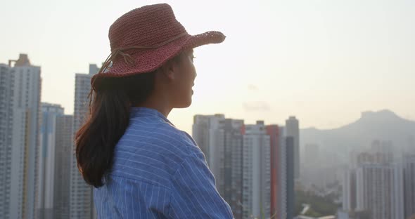 Smile young woman look around in the city and wearing red straw hat