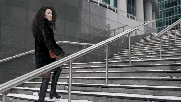 Stylish Sexy Brunette Lady Is Walking in Modern District of Big City at Winter Day Going Up Over