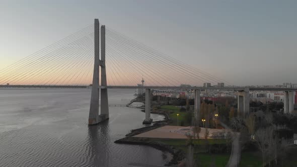 Vasco da Gama Bridge and Lisbon coastline at sunset, Portugal. Aerial approach