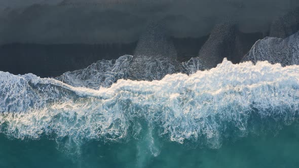 Aerial view of ocean wave splashes into the sand coast