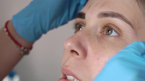 Female Eyebrows and Eyes Closeup the Paint is Removed From the Eyebrows with a Damp Cotton Pad