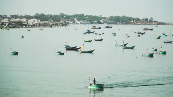 Scene with anchored boats and unrecognizable fishermen sailing. Static