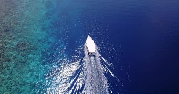 Beautiful birds eye tourism shot of a sandy white paradise beach and blue ocean background 