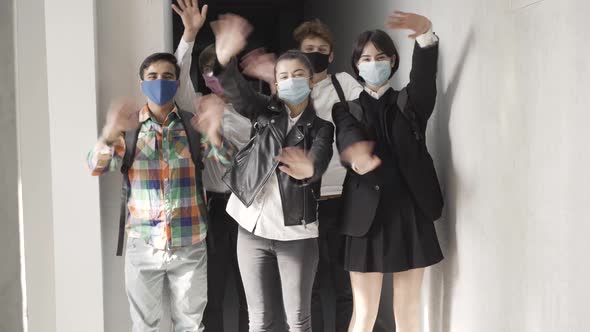 Positive High School Students in Covid Face Masks Waving at Camera and Smiling