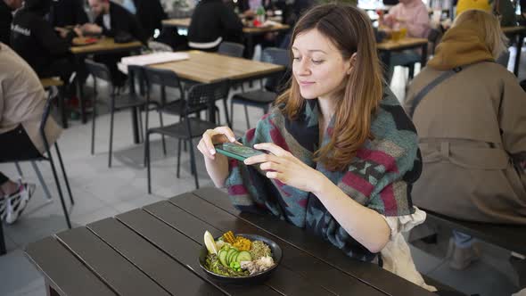 Woman Makes Photo of Food Bowl with Mobile Phone in Cafe