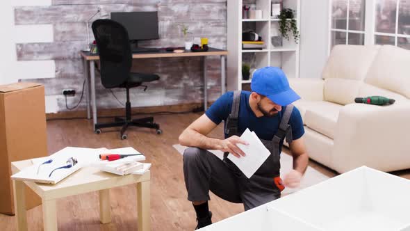 Confused Male Worker While Assembling a Shelf