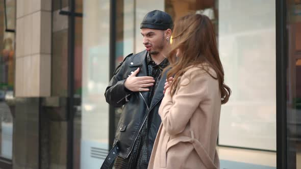 Side View Stylish Caucasian Gay Man and Young Woman Standing on City Street Mocking Discussing