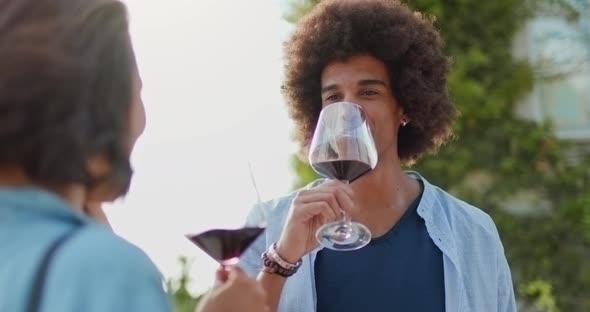 Romantic Couple, Man Toasting and Smiling with Red Wine at Sunset Warm Light. Friends Italian Trip