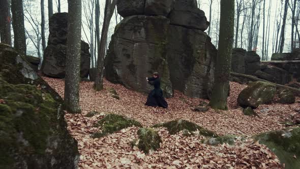 Man in Traditional Japanese Clothes, with a Sword, a Katana, Trains Martial Arts in the Forest