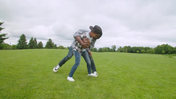 Carefree Black Family Fighting for Ball Possession During Football Game