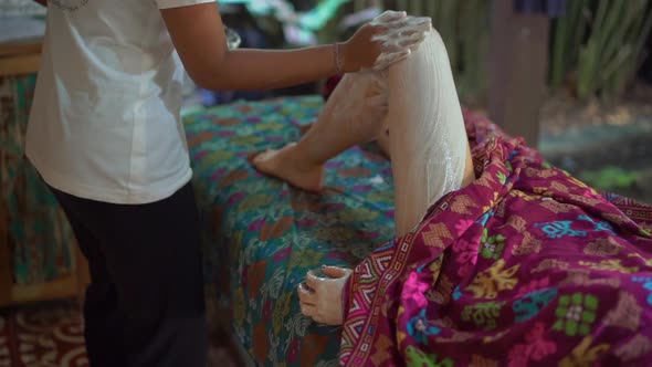 Closeup Shot of A Young Woman in A Tropical Spa. Beautician Applies Skin Moisturizer