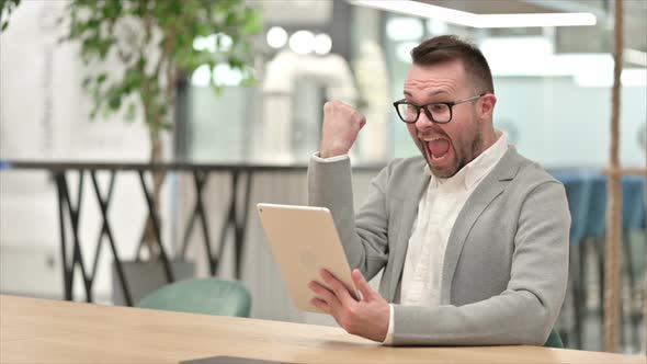 Excited Creative Man Celebrating Success on Tablet