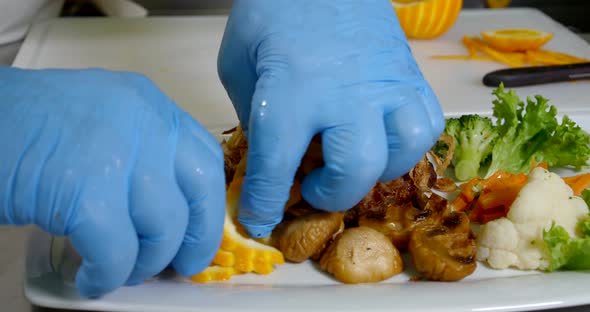 Hands of Professional Cook with Protective Rubber Gloves, Putting Decorations on Plate