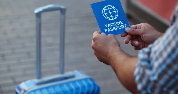 Cropped Shot of Man with Suitcase and Vaccine Passport