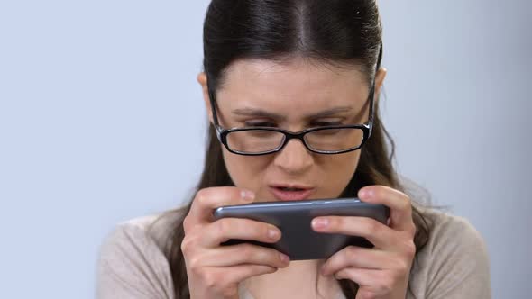 Woman in Eyeglasses Playing Game on Smartphone, Bad Gadget Influence on Vision
