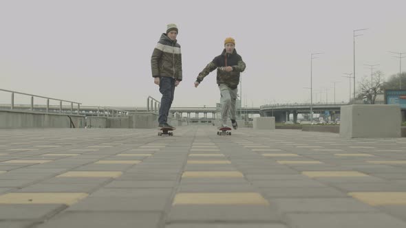 Teenage Boys Riding Skateboards on Sidewalk in City