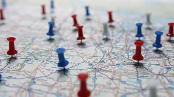 Camera flight revealing red white and blue pins placed marking cities on a US map or map of the USA