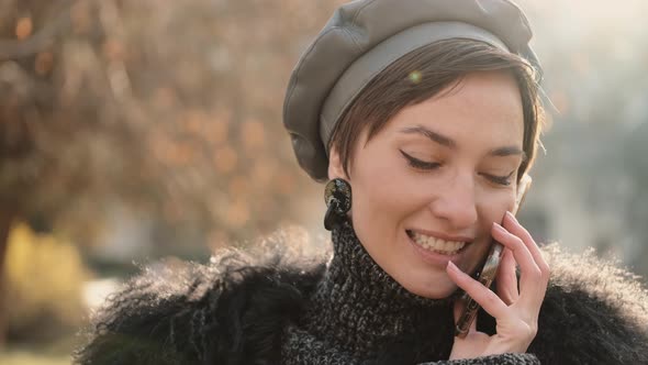 Close Up of a Gorgeous Happy Stylish Woman Smiling and Talking By Phone