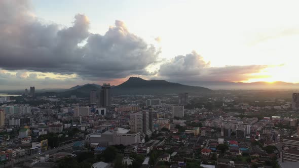 Aerial view drone moving slow motion scene of cityscape with sky sunrise over the mountain.