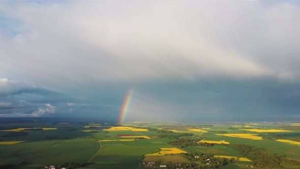 The Rainbow Over Agriculture Landscape Many Fields of Yellow Rapeseed Aerial View 4K