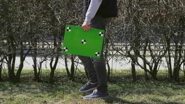 Guy Holds Chroma Key Poster, Could Be a Postman. Man's Table with Motion Points.