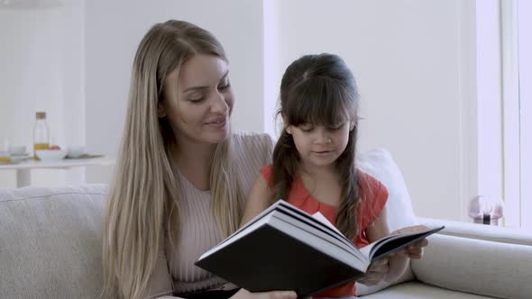 Little Girl and Her Mom Reading Book Together