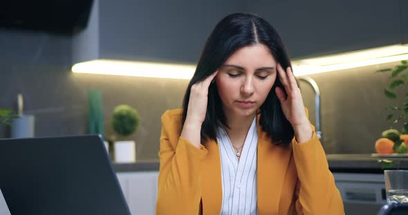 Woman Sitting Near Computer and Different Documents and Massaging Her Temples Closed Eyes