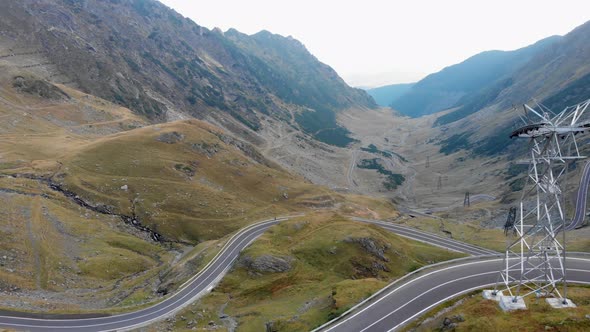 Aerial shot, drone flying over Transfagarasan mountain and winding roads in Romania. Camera passing