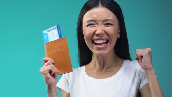 Excited Asian Lady Holding Passport and Flight Tickets, Work Abroad, Emigration