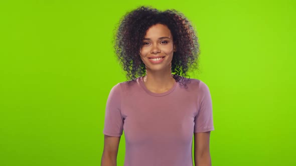 Portrait of African American Young Woman with Curly Hair Flirts on Green Screen