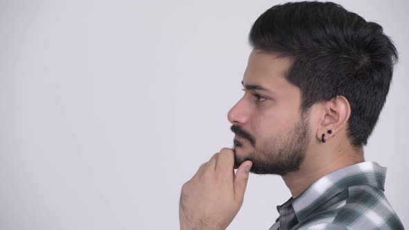 Profile View of Young Happy Bearded Indian Man Thinking