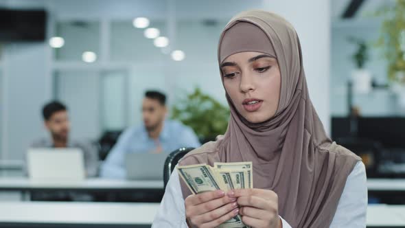 Serious Concentrated Eastern Muslim Girl in Hijab Office Worker Manager or Accountant Holding Bundle