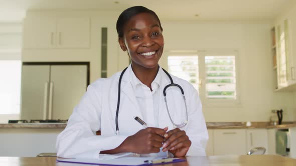 African happy american female doctor waving hand during video call consultation