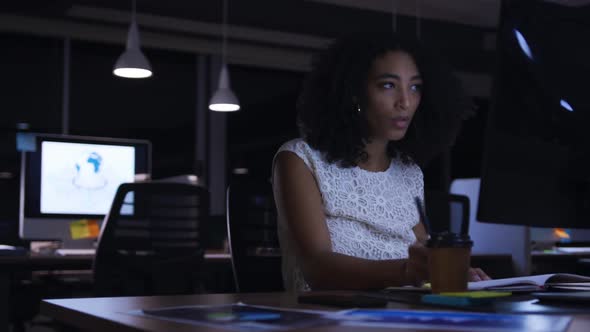 Businesswoman working in a modern office by night