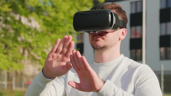 Man Wearing Virtual Reality Headset and Manage the Interface in Augmented Reality