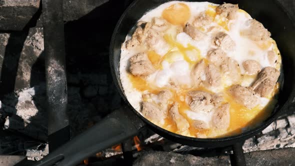 Cooking Scrambled Eggs with Chicken Meat on Tourist Campfire Frying Pan Nature