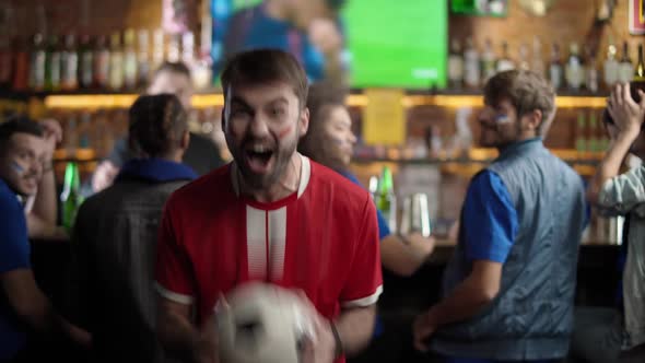 Football Fans Drink Beer and Watching a Football Match at the Bar Fan of the Opposite Team Enjoy