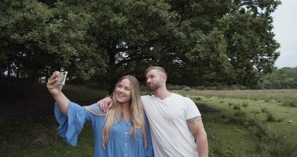 Couple in the Open Fields Taking a Selfie with a Smartphone