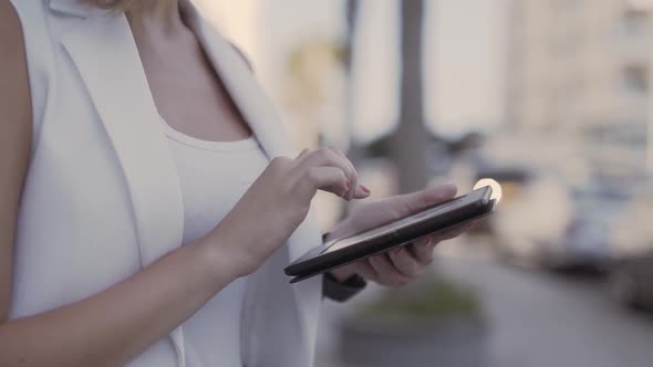 Closeup of Young Woman's Hands Using Tablet in City