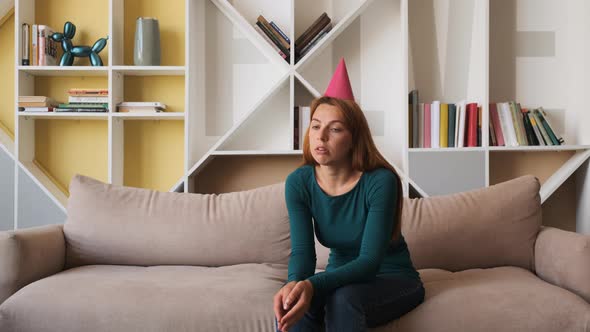 Sad Young Woman Celebrates Birthday Alone in the Living Room